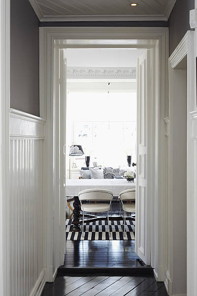 skandynawski korzytarz,białe deski na scianach,drewniany sufit,wąski korytarz,aranżacja wąskiego korytarza,czarna podłoga