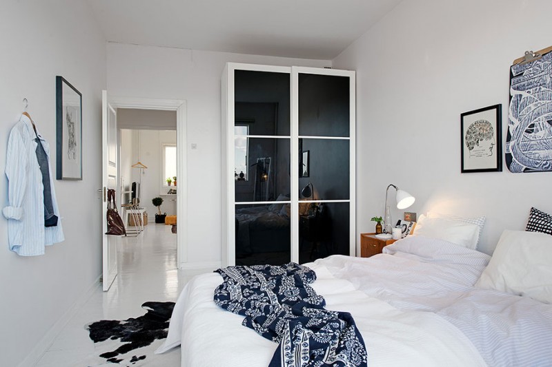 biało-czarna sypialnia,skandynawska sypialnia,nowoczesna sypialnia,czarn-biały koc,drewniana komoda,iałe wnętrze,czarna szafa,czarno-biała skóra,czarno-biały dywan