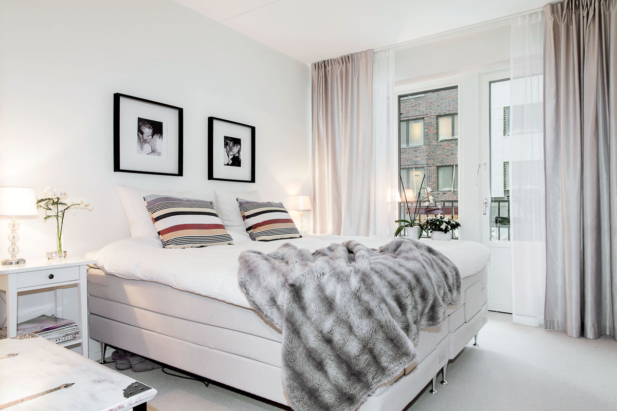 skandynawska sypialnia,aranżacja skandynawskiej sypialni,futrzana narzuta,futrzany szary pled,białe łóżko,poduszki w szaro-beżowe pasy,jak urządzić sypialnie skandynawską w nowoczesnym stylu