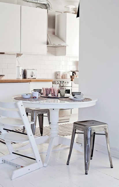 stylowy stół w skandynawskiej kuchni,stylowy stół biały,biały okragły stół w skandynawskiej aranżacji,różne krzesła przy jednym stole,skandynawskie krzesła przy stylowym stole,biały stół na jednej nodze