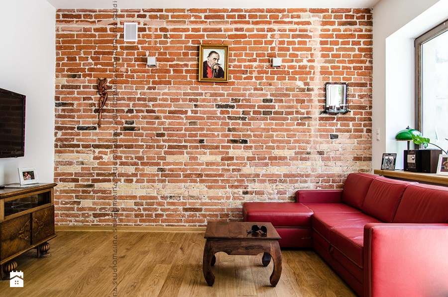 czerwone cegły na całej ścianie w salonie