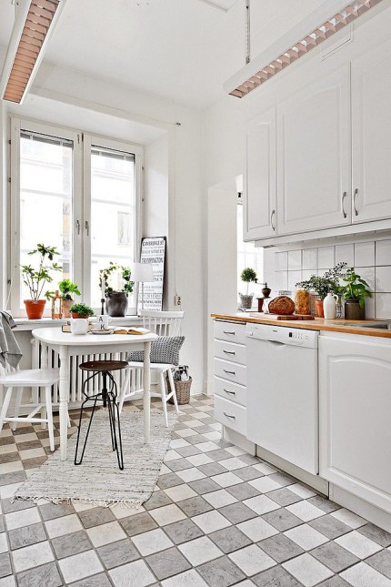 biały stół i krzesła w kuchni,kuchnia w stylu skandynawskim,styl skandynawski w białej kuchni,bialo-szara terakota w kuchni,industrialny stołek i drewniane krzesła skandynawskie,białe krzesła z drewna w stylu skandynawskim