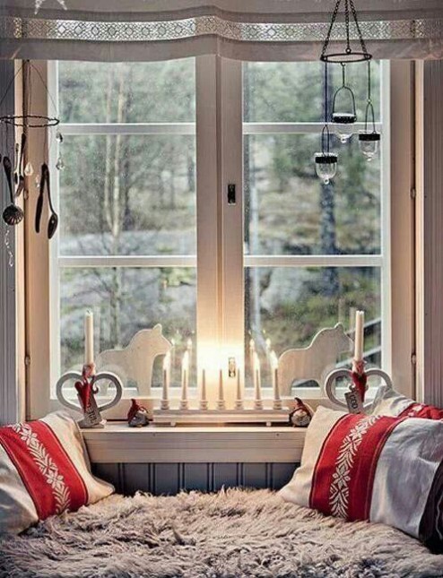czerwone poduszki w świątecznej aranzacji,okna w świątecznej dekoracji,siedziska przy świątecznym oknie,aranzacje świąteczne na oknach,czerwony kolor świątecznych dekoracji