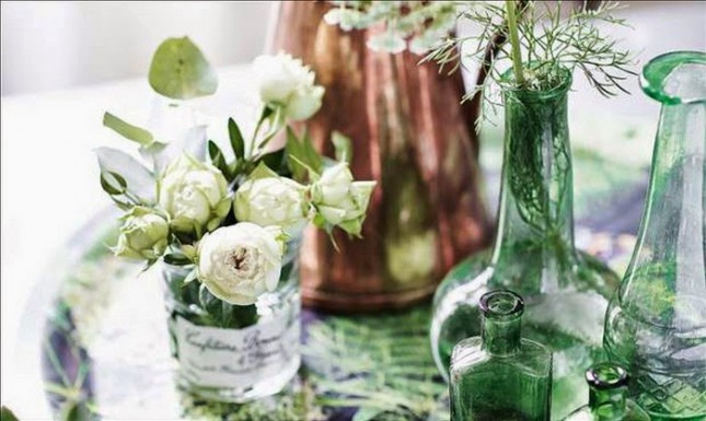 biało-zielona aranzacja wiosennego stołu,szklane słoje dekoracyjne,zielone butle i wazony szklane,botaniczne plakaty na ściany,drewniany stół w wiosennej dekoracji,wiosenna aranżacja jadalni,obrusy i serwety w z botanicznymi wzorami,botaniczne wzory dekoracji do wnętrz,biało-zielone dekoracje ,biało-zielone poduszki w kwiatowe wzory,jak urządzić jadalnię na wiosnę