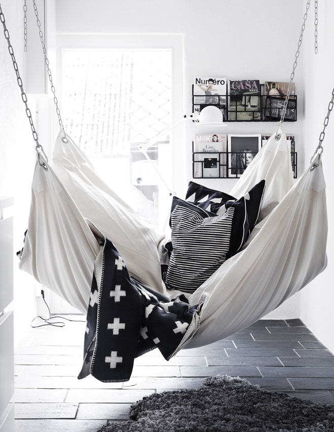 miękki hamak w domu,biała wisząca kanapa z poduszkami,biało-czarne poduszki dekoracyjne,relaks w domu