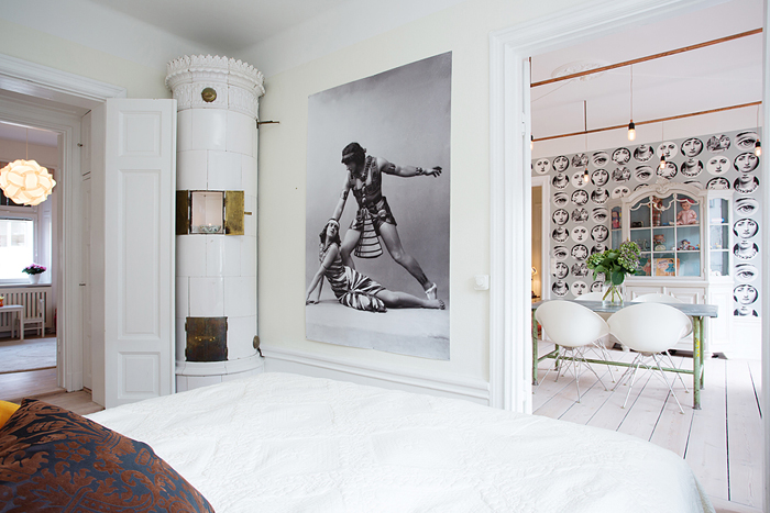 aranżacja skandynawskiej sypialni,ceramiczny piec w sypialni,okrągły piec skandynawski,duże fotografie na ścianach
