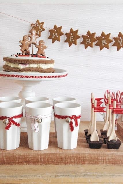 białe kubki,świąteczna oprawa stołu,dekoracje świateczne na stole,czerwone wstążki i etykiety świątreczne