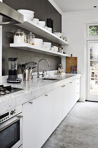 biało-szara kuchnia,betonowe ściany w kuchni,białe półki kuchenne,minimalistyczna biała kuchnia z  betonową ścianą
