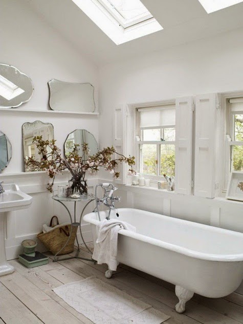 łazienka z galerią dekoracyjną z lustrami,różne lustra na ścianie w  białej łazience,okrągłe i prostokatne lustra ozdobne w łazience