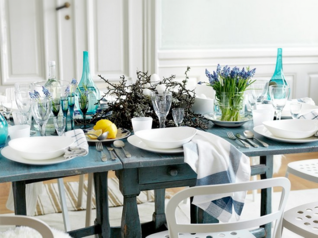 aranżacja wiosenna stołu z kwiatami i turkusowymi butelkam