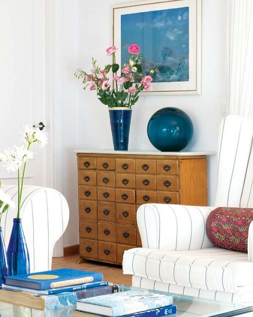 drewniana komoda,niebieskie szkło,biała sofa,śródziemnomorski styl,salon na niebiesko i biało